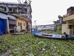 A boat sits stranded in an inundated area with water hyacinths after monsoon rains in Prayagraj on Monday. (PTI)