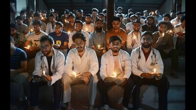 Medical interns, including MBBS and BDS students, hold lit candles and shout slogans during an evening demonstration, in Srinagar, on Monday. (PTI)