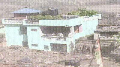 Despite the destruction after the floods, the green house stood erect, with its residents seen standing huddled in the balcony. (X/ @Deb_livnletliv) Despite the destruction after the floods, the green house stood erect, with its residents seen standing huddled in the balcony. (X/ @Deb_livnletliv)