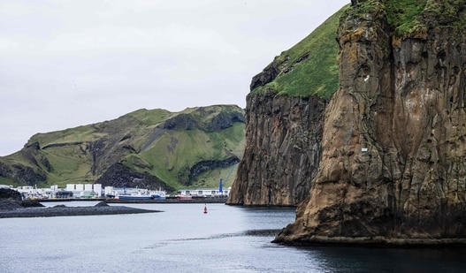 The entrance to the harbour of Heimaey, surrounded by steep volcanic cliffs in Iceland’s Westman Islands (Vestmannaeyjar), on August 26, 2026. The harbour is a key hub for the island’s fishing industry and maritime connections with mainland Iceland.