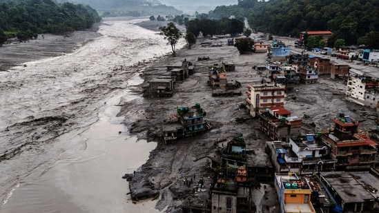 A drone view shows damaged buildings and houses covered in mud next to the Likhu River following deadly flash floods and mudslides, in Devighat, Nuwakot district, Nepal. 