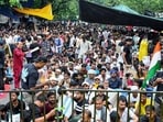 People sit at the protest site at Jantar Mantar supporting the Cockroach Janata Party's (CJP) protest, demanding the Union Education Minister Dharmendra Pradhan's resignation.