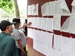 People check lists of rescued and missing persons to find information about their relatives amid ongoing rescue operations following the floods, in Bidur on Monday. (ANI Video Grab)