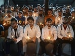 Medical interns, including MBBS and BDS students, hold lit candles and shout slogans during an evening demonstration, in Srinagar, on Monday. (PTI)