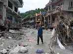 A man walks past damaged houses following flash floods at Devighat in Nepal's Nuwakot district. 