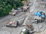 An aerial view shows a torrent of muddy water surging past houses and through the Trishuli River in the aftermath of flash floods at Trishuli Center in Nepal's Nuwakot district. 