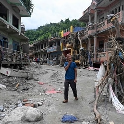 A man walks past damaged houses following flash floods at Devighat in Nepal's Nuwakot district. 
