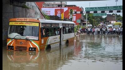 Passengers look out from inside a UPSRTC bus stranded at a waterlogged underpass following heavy rain, in Mirzapur, Tuesday. (PTI Photo) Passengers look out from inside a UPSRTC bus stranded at a waterlogged underpass following heavy rain, in Mirzapur, Tuesday. (PTI Photo)