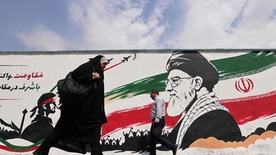 Pedestrians walk past a wall mural of Iran's slain supreme leader Ayatollah Ali Khamenei, along a street in downtown of Tehran on August 31. (AFP) Pedestrians walk past a wall mural of Iran's slain supreme leader Ayatollah Ali Khamenei, along a street in downtown of Tehran on August 31. (AFP)