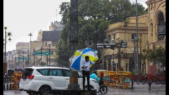 A traffic police personnel regulates traffic amid heavy rainfall, in Lucknow on Tuesday. (ANI)