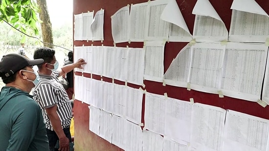 People check lists of rescued and missing persons to find information about their relatives amid ongoing rescue operations following the floods, in Bidur on Monday. (ANI Video Grab) (ANI Video Grab)