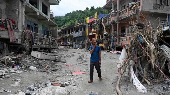 A man walks past damaged houses following flash floods at Devighat in Nepal's Nuwakot district.