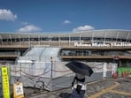 (FILES) This picture taken on September 7, 2025 shows a woman shielding herself from the hot sun with an umbrella as she walks past the Nagoya City Mizuho Park Athletic Stadium, the venue for track and field and marathon competitions in the upcoming 2026 Aichi-Nagoya Asian Games in Nagoya, Aichi prefecture. (Photo by Yuichi YAMAZAKI / AFP) (AFP)