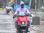 Commuters seen during sudden rains at South Extension in New Delhi. (Hindustan Times)