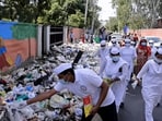 Members of the Congress Seva Dal spraying DPT on the garbage heaps at several locations in Rohtak. (HT Photo)