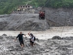 Residents pull the steel wire of a newly installed zipline to help people commute across the Trishuli River in the aftermath of flash floods at Bidur in Nepal's Nuwakot district, Nepal. (AP )