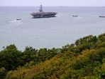 Tugboats prepare to guide US nuclear-powered aircraft carrier USS Abraham Lincoln (CVN-72) (C) towards Laem Chabang Port, near the city of Pattaya.