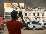 A man takes a photo of firefighters working at a site of a warehouse hit by a Russian drone strike, amid Russia's attack on Ukraine, in the Kyiv region, Ukraine, August 31, 2026. REUTERS/Alina Smutko     TPX IMAGES OF THE DAY