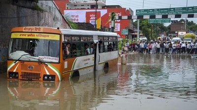 Passengers look out from inside a UPSRTC bus stranded at a waterlogged underpass following heavy rain, in Mirzapur, Tuesday. (PTI) Passengers look out from inside a UPSRTC bus stranded at a waterlogged underpass following heavy rain, in Mirzapur, Tuesday. (PTI)