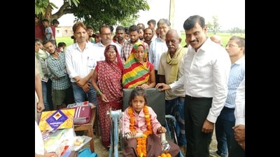 Ragini in her new tricycle with the Ballia DM (HT Photo) Ragini in her new tricycle with the Ballia DM (HT Photo)