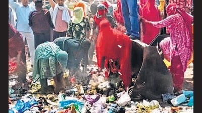 Sanitation workers obstructing movement of a JCB removing garbage in Rohtak on Wednesday. (HT Photo)
