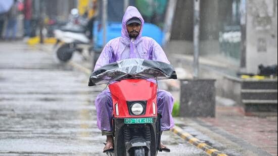 Commuters seen during sudden rains at South Extension in New Delhi. (Hindustan Times)