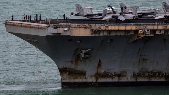 The U.S. Navy Nimitz-class aircraft carrier USS Abraham Lincoln sails toward Laem Chabang Port before docking for a rest stop following a long deployment in the Middle East.
