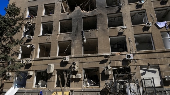 A worker removes debris in front of a building of a business centre hit by a Russian drone strike, amid Russia's attack on Ukraine, in Odesa, Ukraine September 2, 2026. 