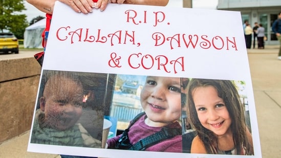 A woman carries a sign to show support for the three murdered children of Lindsay Clancy during the Clancy's murder trial at Plymouth Superior Court in Plymouth, Massachusetts on September 1, 2026. (Photo by JOSEPH PREZIOSO / AFP)