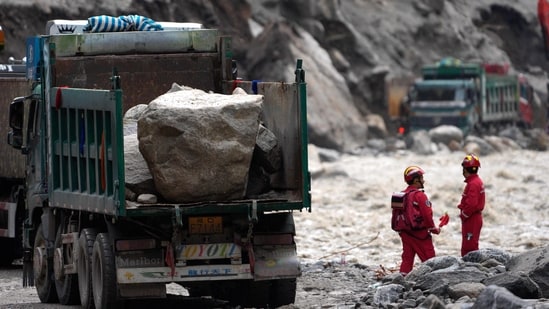 Trucks carrying stones are seen at the road clearing site as rescue personnel work to restore access to the mudslide-hit Gyirong Port in Gyirong County, in China's western Tibet Autonomous Region.