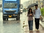 People are seen taking shelter amid rain.