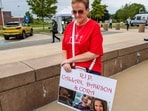 A woman carries a sign to show support for the three murdered children of Lindsay Clancy during the Clancy's murder trial at Plymouth Superior Court in Plymouth, Massachusetts on September 1, 2026. Lindsay Clancy is on trial for the January 2023 strangulation deaths of her three young children. (Photo by JOSEPH PREZIOSO / AFP)