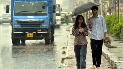People are seen taking shelter amid rain. (Sakib Ali/HT photo)
