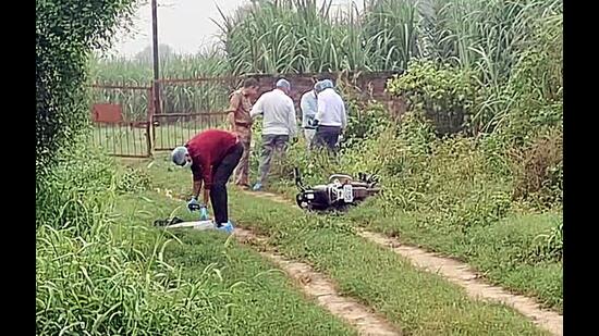 Forensic team and police personnel inspect the encounter site where a motorcycle lies on the ground after two prime shooters in the Ankit Balyan murder case were killed, in Shamli recently. (ANI Video Grab)