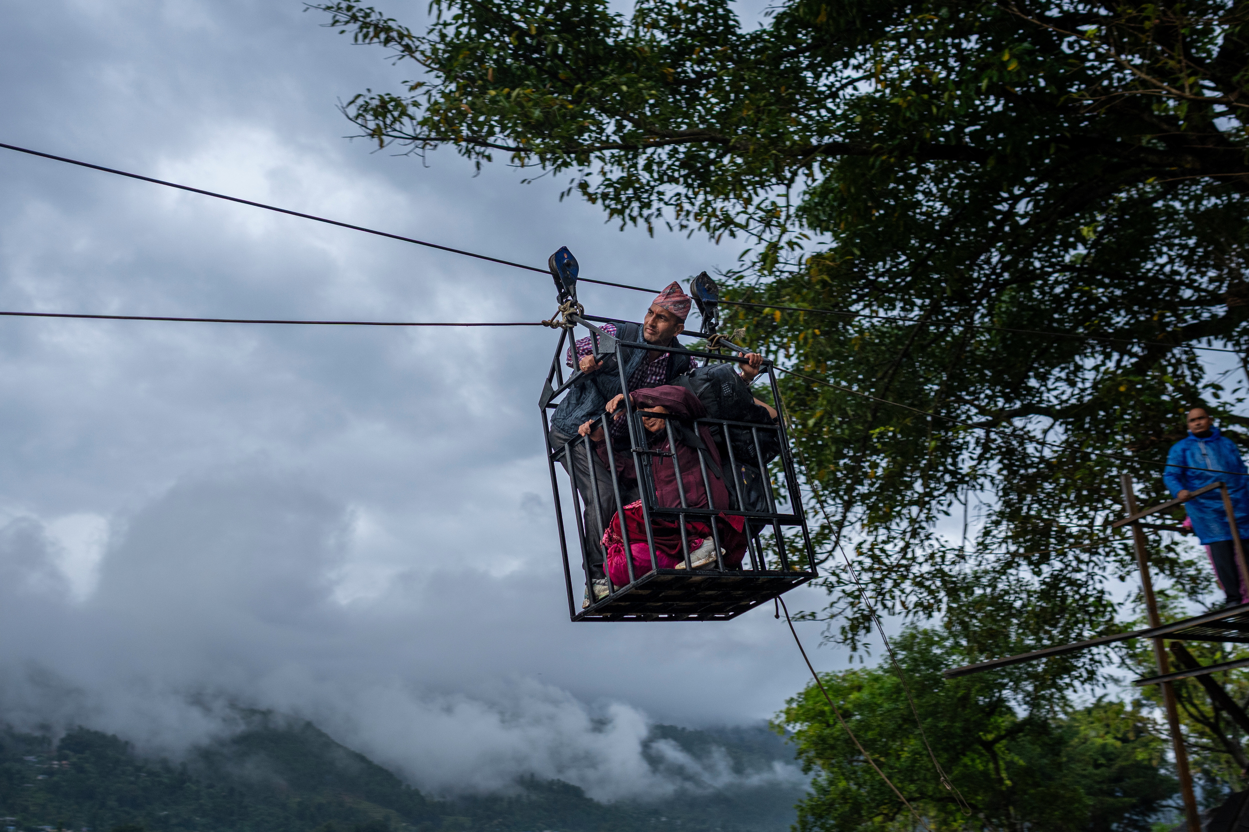 Residents commute across the Trishuli river on a newly installed zipline in the aftermath of flash floods at Bidur in Nepal's Nuwakot district, Nepal, Sept. 2, 2026. (AP Photo/Rajesh Kumar Singh)