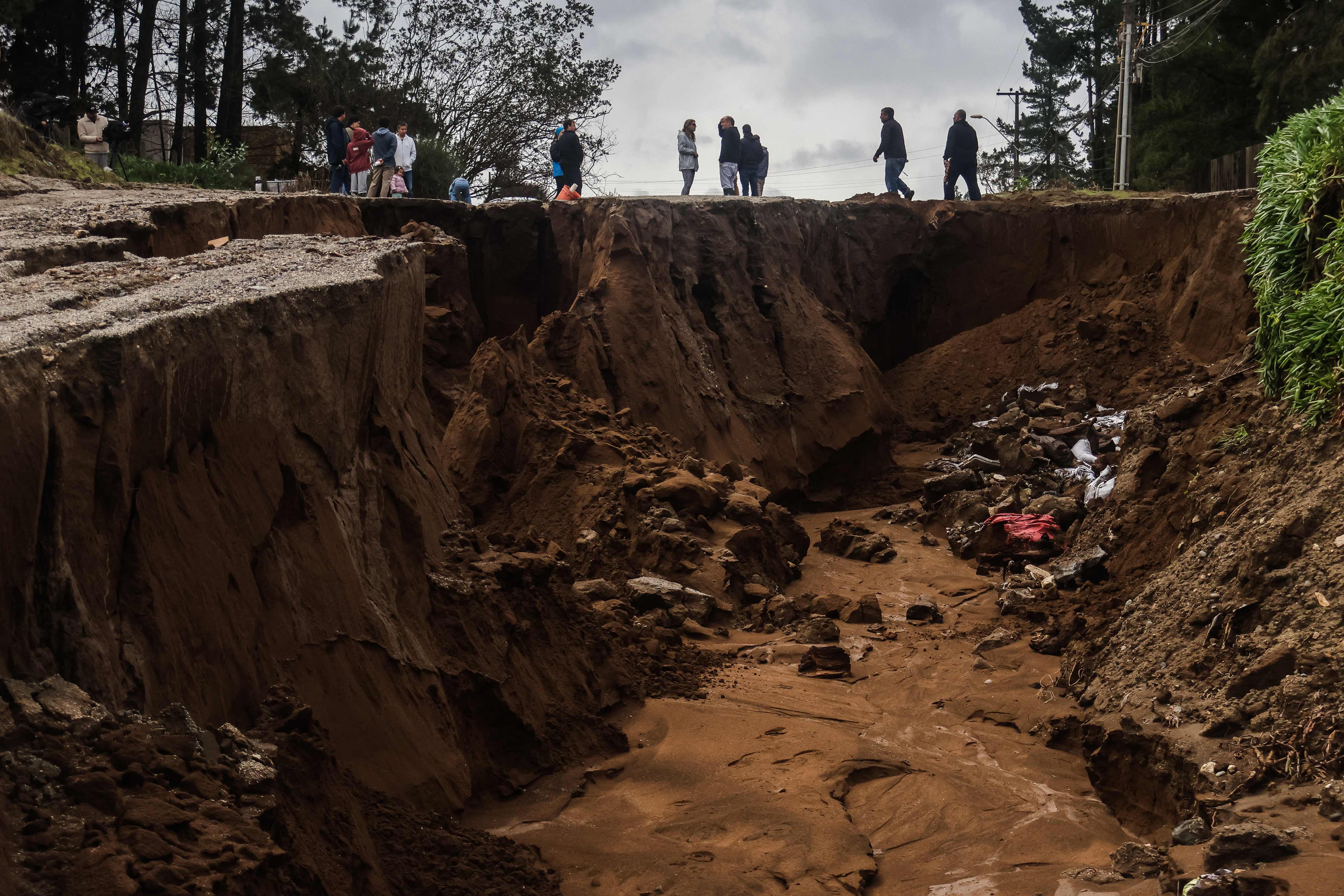 People stand next to a large sinkhole in Viña del Mar, Chile, on July 18, 2026, as the UN climate agency warns El Niño is near-certain to become "very strong." (Photo by Cristobal Basaure / AFP) (AFP) People stand next to a large sinkhole in Viña del Mar, Chile, on July 18, 2026, as the UN climate agency warns El Niño is near-certain to become "very strong." (Photo by Cristobal Basaure / AFP) (AFP)