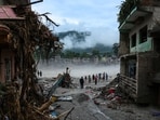 People stand next to damaged buildings following the deadly flash floods and a mudslide, in Devighat, Nuwakot district, Nepal, September 4, 2026. (REUTERS)
