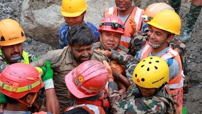 Survivor Sanjay Sah is carried by members of a search and rescue team after they rescued two people alive who had been trapped inside a tunnel in Rasuwa, Nepal. (REUTERS)