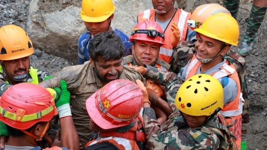 Survivor Sanjay Sah is carried by members of a search and rescue team after they rescued two people alive who had been trapped inside a tunnel in Rasuwa, Nepal.