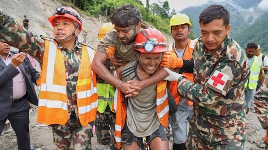 Nepal army personnel and other officials rescue a man from the tunnel of the Trishuli 3A Hydropower Project, in the aftermath of the recent flash floods, in Rasuwa district. (HT Photo)