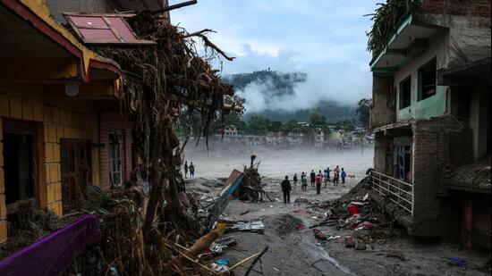 People stand next to damaged buildings following the deadly flash floods and a mudslide, in Devighat, Nuwakot district, Nepal, September 4, 2026. (REUTERS)
