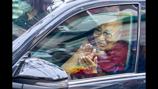 Tibetan spiritual leader the Dalai Lama greets devotees from inside his car upon his arrival in Dharamshala on Friday. (AP Photo)