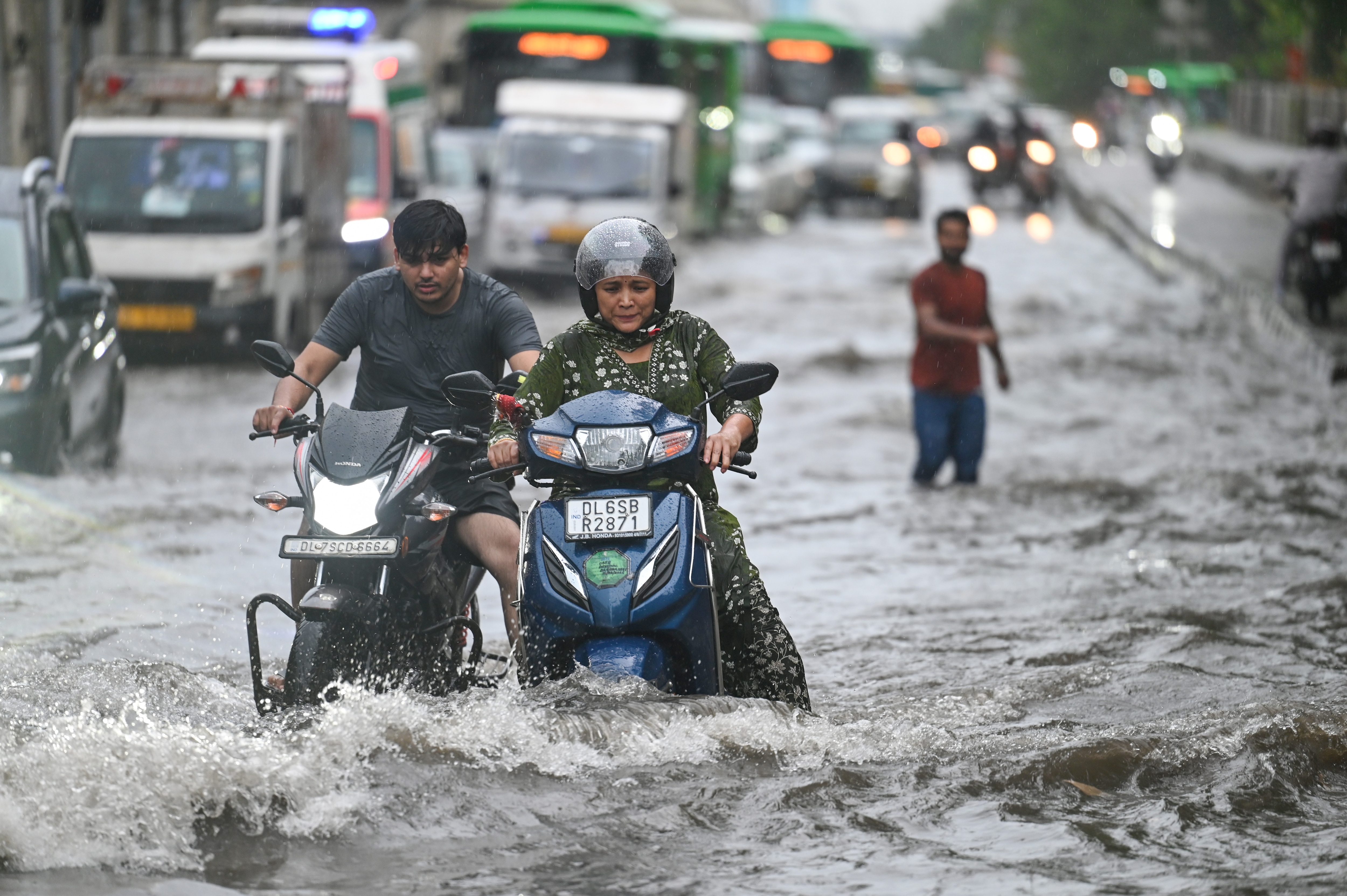 Commuters wade through a water logged stretch at Mayur Vihar Phase 2 near  NH24 amid heavy rains  in New Delhi (Raj K Raj/HT Photos )