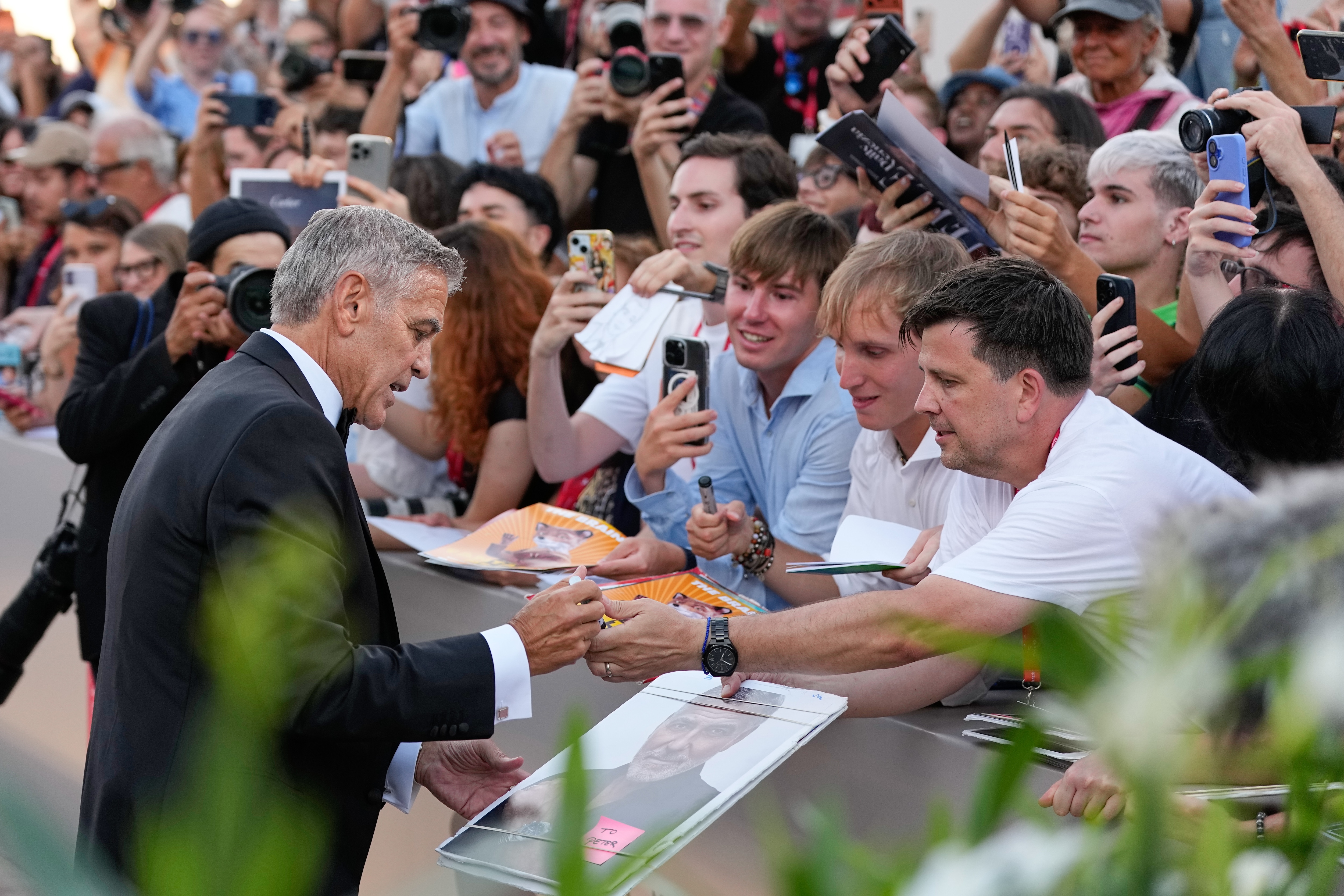 George Clooney signs auotographs at the opening ceremony and the red carpet for the film 'Ink' during the 83rd edition of the Venice Film Festival in Venice, Italy, on Wednesday, Sept. 2, 2026. (Photo by Alessandra Tarantino/Invision/AP) (AP Photo/Alessandra Tarantino)