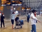 Passengers with their luggage walk through the waterlogging conditions at Indira Gandhi International Airport after heavy rainfall.
