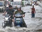 Commuters wade through a waterlogged stretch.