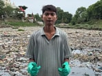 Bittu Tabahi cleans garbage from a river ghat.