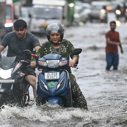 Commuters wade through a waterlogged stretch. 