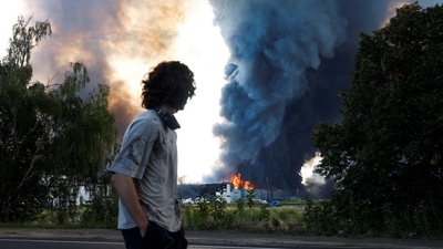 A man looks on as smoke rises over a warehouse, which was hit by a Russian drone strike, amid Russia's attack on Ukraine, in Kyiv region, Ukraine. (REUTERS/File Photo)