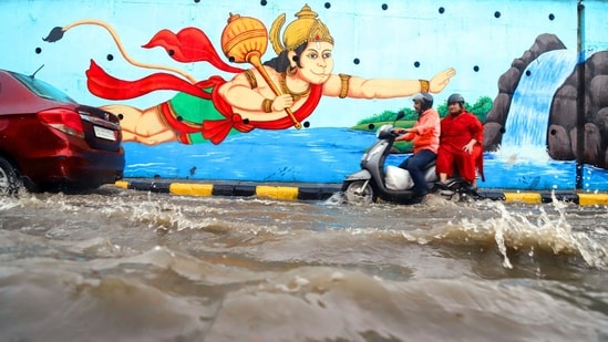 Gram it: Commuters wade through waterlogging at Hanuman Mandir, ISBT, after heavy rainfall on Friday. If one goes by the intensity at which Delhi is witnessing rainfall and waterlogging woes, it sure needs intervention of God Hanuman for commuters to crossover the pools of water that have lead city roads to get submerged. (Photo: Deepak/ANI)